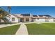 Inviting single-story home with solar panels, a well-maintained lawn, and mature palm trees at 8515 Belcastro St, Las Vegas, NV 89113