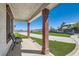 Covered front porch featuring decorative pillars, stone accents, and views of the lush lawn at 8515 Belcastro St, Las Vegas, NV 89113
