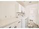 Neat laundry room equipped with white appliances, storage cabinets, and tile flooring at 8515 Belcastro St, Las Vegas, NV 89113