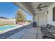Inviting covered patio with ceiling fan, seating, and a view of the pool and landscaped backyard at 8515 Belcastro St, Las Vegas, NV 89113