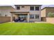 Well-maintained backyard with artificial turf, covered patio, and outdoor seating, perfect for relaxation and entertaining at 8564 Scalpay St, Las Vegas, NV 89166