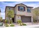 Two story home exterior with a two car garage, desert landscaping and brick paver walkway at 8564 Scalpay St, Las Vegas, NV 89166