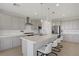 Spacious kitchen with white cabinets, quartz countertops, island with seating, and tile floor at 8564 Scalpay St, Las Vegas, NV 89166