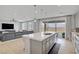 Modern kitchen island with quartz countertop, stainless steel appliances, and view into the living room at 8564 Scalpay St, Las Vegas, NV 89166