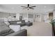 Spacious living room with a large sectional sofa, open floor plan, and a ceiling fan at 8564 Scalpay St, Las Vegas, NV 89166