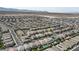 An aerial view of a residential neighborhood featuring numerous homes, tidy streets, and mountain views at 8564 Scalpay St, Las Vegas, NV 89166