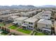 An aerial view of a residential area, showcasing houses with manicured lawns and mountain views at 8564 Scalpay St, Las Vegas, NV 89166