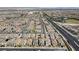 A wide aerial shot shows a residential community with streets, houses, and community amenities at 8564 Scalpay St, Las Vegas, NV 89166