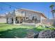 Backyard oasis featuring a covered patio, artificial turf, and outdoor seating area at 8725 Hawk Canyon St, Henderson, NV 89074