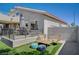 Relax in style in this backyard featuring shaded dining, fire pit, putting green, and artificial turf at 8725 Hawk Canyon St, Henderson, NV 89074