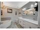 Bathroom with a double vanity, soaking tub, modern chandelier, and elegant fixtures at 8725 Hawk Canyon St, Henderson, NV 89074