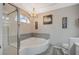 Serene bathroom featuring a luxurious soaking tub with chandelier and stylish decor at 8725 Hawk Canyon St, Henderson, NV 89074