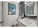 Modern half-bathroom with sleek fixtures and a stylish dark grey accent wall at 8725 Hawk Canyon St, Henderson, NV 89074