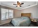 A bright bedroom with a large window, ceiling fan, and comfortable bed at 8725 Hawk Canyon St, Henderson, NV 89074