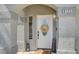 Charming entryway featuring a decorative wreath, welcome sign and a well-lit porch at 8725 Hawk Canyon St, Henderson, NV 89074