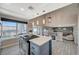 Modern kitchen features a center island with a stovetop, backyard access and tiled floors at 8725 Hawk Canyon St, Henderson, NV 89074