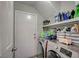 Efficient laundry area with modern washer, dryer, and ample storage shelves at 8725 Hawk Canyon St, Henderson, NV 89074