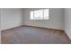 Spacious bedroom with large window offering neighborhood views and plush carpeting at 8771 Martinique Bay Ln, Las Vegas, NV 89147