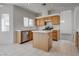Open kitchen with wooden cabinets, tile floors, and stainless steel appliances at 8771 Martinique Bay Ln, Las Vegas, NV 89147