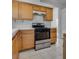 Kitchen with stainless steel range, wooden cabinets, and tile backsplash at 8771 Martinique Bay Ln, Las Vegas, NV 89147