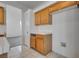 Kitchen featuring wooden cabinets and tile floors, with a view to the laundry at 8771 Martinique Bay Ln, Las Vegas, NV 89147