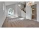 Large living room with neutral carpet, high ceilings, bright windows, and open access to the entryway and staircase at 8771 Martinique Bay Ln, Las Vegas, NV 89147