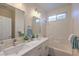 Bathroom featuring a double sink vanity with modern fixtures, tub with tile surround, and a window at 9193 Black Slate St, Las Vegas, NV 89123
