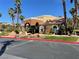 A clubhouse with a terra cotta roof and arches is framed by palm trees and landscaping at , Henderson, NV 89014