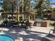 Outdoor grill and dining area features tables with umbrellas and a stainless steel barbecue grill near the pool at , Henderson, NV 89014