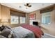 Bedroom with two windows, ceiling fan, and queen bed dressed in grey and red plaid bedding at 1541 Unison Way # 102, Las Vegas, NV 89135