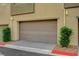 Garage entrance of unit 102 with landscaping along the front and a paved driveway at 1541 Unison Way # 102, Las Vegas, NV 89135
