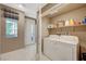 Well-equipped laundry room with washer, dryer, shelf storage, and exterior access at 1541 Unison Way # 102, Las Vegas, NV 89135