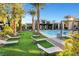 Resort-style pool area with lounge chairs, desert landscaping, and mature palm trees at 1541 Unison Way # 102, Las Vegas, NV 89135