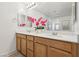 Double sink vanity adorned with pink orchids and decorative mirror at 160 Lilt Ave, Henderson, NV 89011