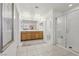 Modern bathroom featuring double sinks, wooden cabinets, and a glass-enclosed shower at 160 Lilt Ave, Henderson, NV 89011