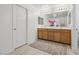 Bathroom featuring double sinks, wooden cabinets, a large mirror, and a white door at 160 Lilt Ave, Henderson, NV 89011