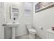 Bathroom featuring a pedestal sink, toilet, and decorative wall art at 160 Lilt Ave, Henderson, NV 89011
