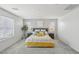 Neutral bedroom featuring a queen bed with a yellow accent blanket and two large windows at 160 Lilt Ave, Henderson, NV 89011