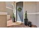 Charming gray front door with wreath, potted plants, and a 'hello' doormat on brick pavers at 160 Lilt Ave, Henderson, NV 89011
