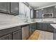 Modern kitchen showcasing white countertops, stainless dishwasher and sink beneath large window at 160 Lilt Ave, Henderson, NV 89011