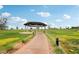 Community park showcasing covered gazebo, walking path, green grass, landscaping, and clear blue skies at 160 Lilt Ave, Henderson, NV 89011