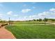 Expansive community park featuring green grass, native landscaping, walking trails, and covered seating under a blue sky at 160 Lilt Ave, Henderson, NV 89011