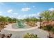 View of the community playground featuring climbing structures, walking path, benches, and native landscaping under a sunny blue sky at 160 Lilt Ave, Henderson, NV 89011