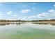 Scenic view of a large pond reflecting the blue sky and clouds, surrounded by community homes and desert landscaping at 160 Lilt Ave, Henderson, NV 89011