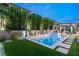 Private backyard with a luxurious pool, meticulously landscaped greenery, and stone pathway at 177 Cactus Sunrise St, Las Vegas, NV 89138