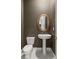 Cozy powder room featuring a pedestal sink, round mirror, and neutral wall color at 177 Cactus Sunrise St, Las Vegas, NV 89138