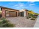 Charming single-story home featuring a brick-accented facade, tile roof, and a spacious driveway, complete with a two-car garage at 177 Cactus Sunrise St, Las Vegas, NV 89138