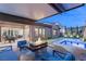 Elegant outdoor space with a cozy seating area, fire pit, dining set, and a modern pool with spa at 177 Cactus Sunrise St, Las Vegas, NV 89138