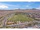 Wide aerial shot of neighborhood park with soccer fields, play area, and community pool set among many homes at 2616 Tolmezzo St, Henderson, NV 89044