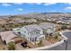 Aerial view of a neighborhood showcasing a gray home with manicured lawns and mountain views at 2616 Tolmezzo St, Henderson, NV 89044